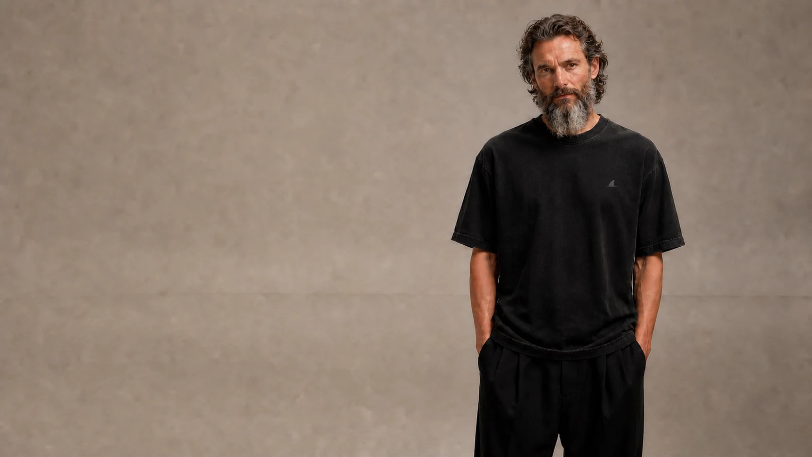 Acheilus heavyweight black casualwear styled in a quiet concrete setting